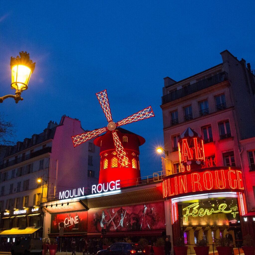 Moulin Rouge, a cabaret in Paris, on the Boulevard de Clichy, at the Place Blanche, the intersection and end of the Rue Blanche.