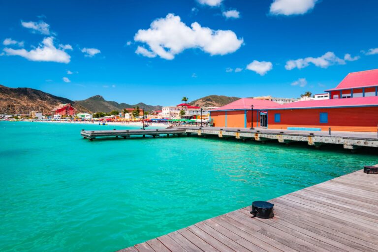 Wooden dock and colorful buildings at Great Bay beach in Philipsburg, Sint Maarten.