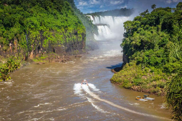A speed boat navigating the Iguazu River towards the Iguazu Falls, located on the border between Argentina and Brazil.
