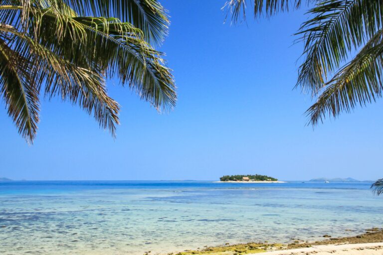 Remote tropical island surrounded by crystal clear waters on a sunny day in Fiji.