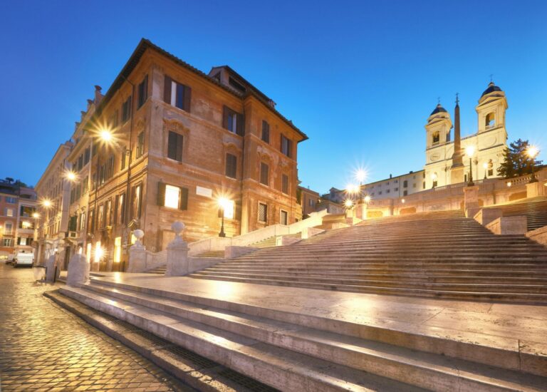 The iconic Spanish Steps in Rome lead up to the Trinita dei Monti church, which overlooks the Piazza di Spagna, a famous hub for tourists and fashion, featuring historic Baroque architecture and designer boutiques.