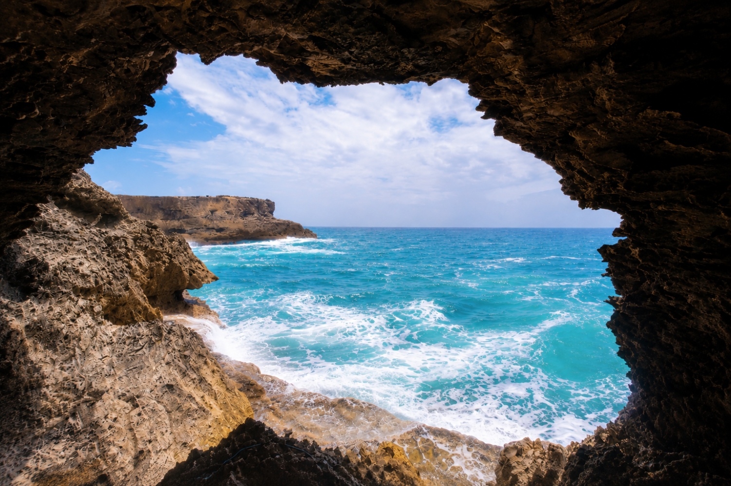A dramatic view of the Atlantic Ocean through a hole in Animal Flower Cave, named for the sea anemones found in its rock pools, which are often referred to as animal flowers.