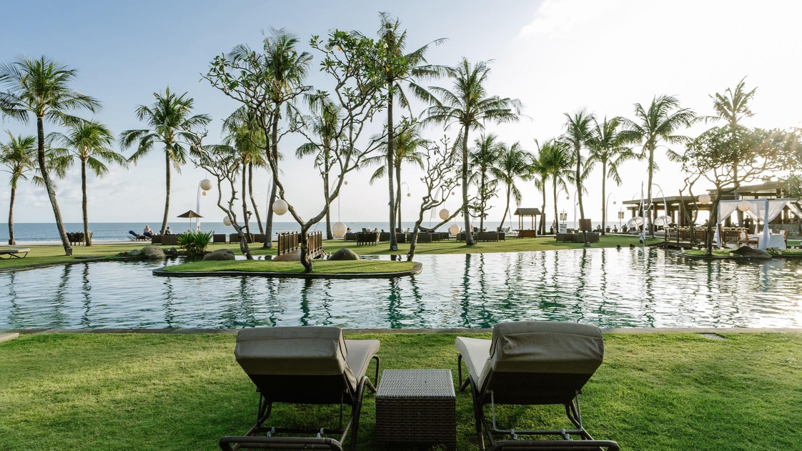 Beachfront infinity pool and tropical gardens at The Samaya Seminyak Bali resort in Indonesia.