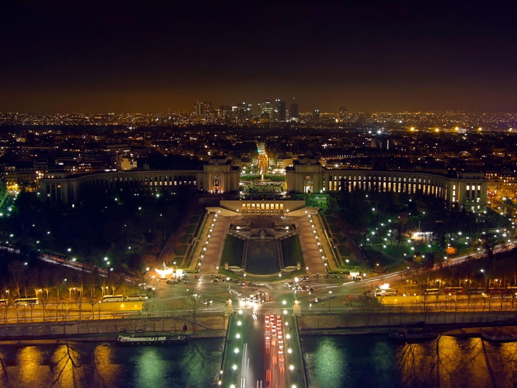 The Palais de Chaillot from the Eiffel Tower, with the La Defense business district illuminated in the background.
