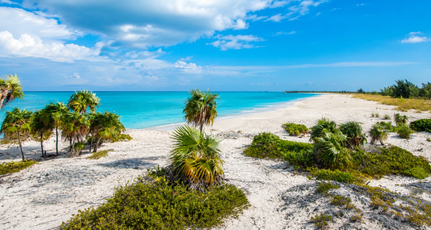 The white sand beach and turquoise waters of Half Moon Bay located between the uninhabited islands of Little Water Cay and Water Cay in the Turks and Caicos Islands.