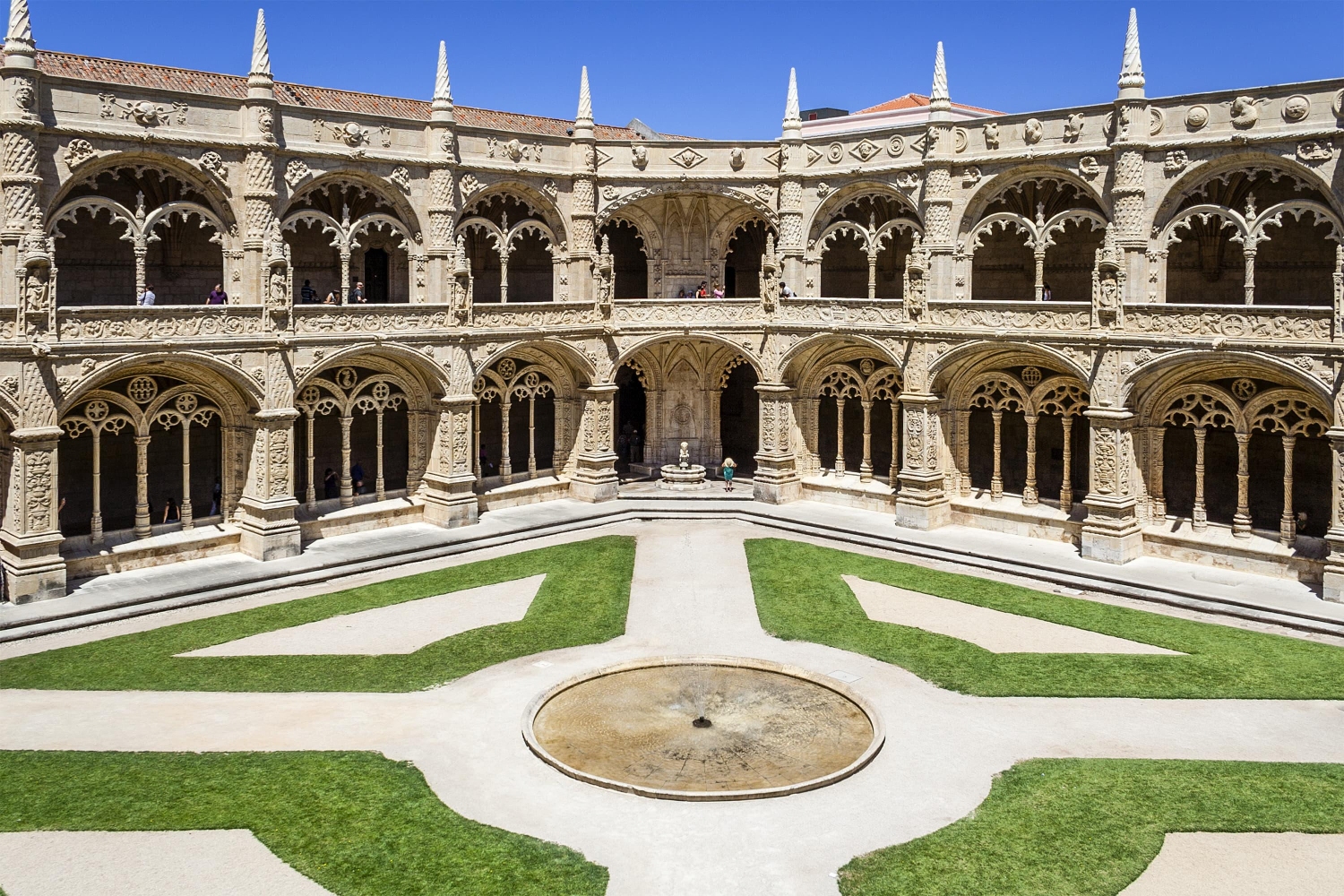 The ornate two-story claustro, or cloister, of the Jeronimos Monastery in Lisbon, Portugal, is a stellar example of Manueline architecture featuring intricate Gothic detailing combined with maritime symbols.