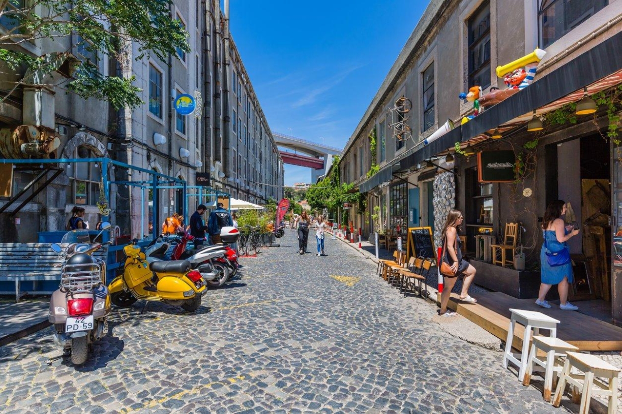 The LX Factory in the Alcantara neighborhood of Lisbon, Portugal is a former industrial complex turned cultural hub featuring cobblestone streets lined with unique shops, restaurants, and bars.