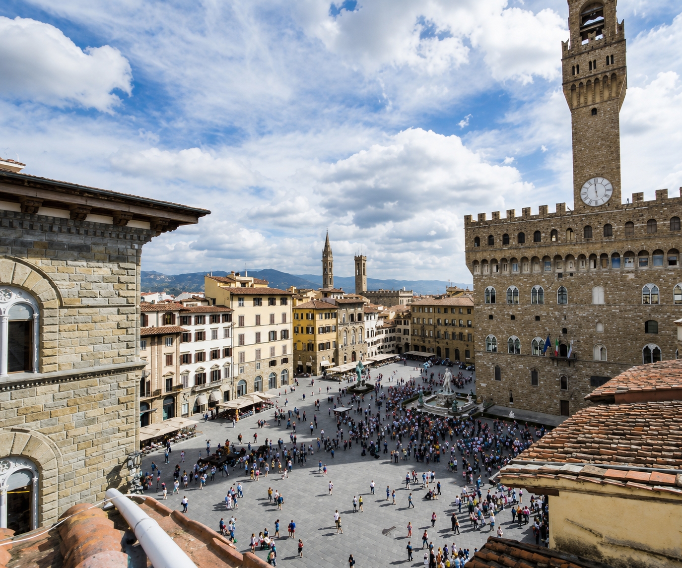 Piazza della Signoria is the political, historical, and artistic heart of Florence, Italy featuring iconic masterpieces and statues including Perseus with the Head of Medusa, the Fountain of Neptune, Hercules and Cacus, Equestrian Monument of Cosimo I and a replica of Michelangelo's David.