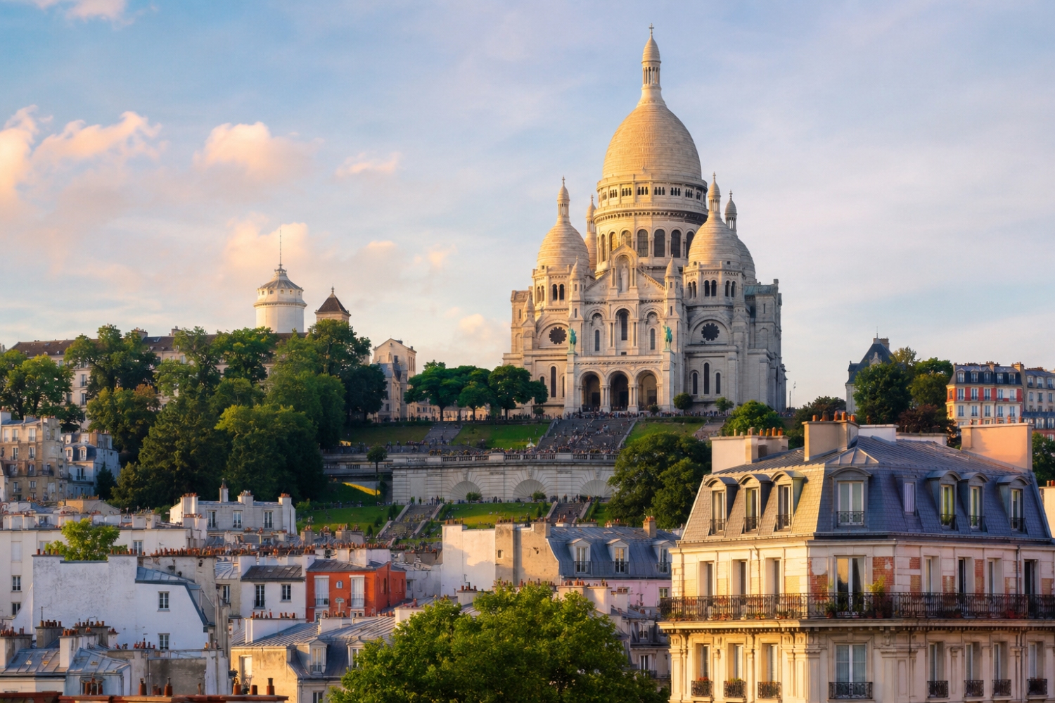 The Sacre Coeur Basilica, recognized for its unique Roman-Byzantine architectural style and its brilliant white travertine facade, sitting atop the highest point in Paris within the Montmartre neighborhood.