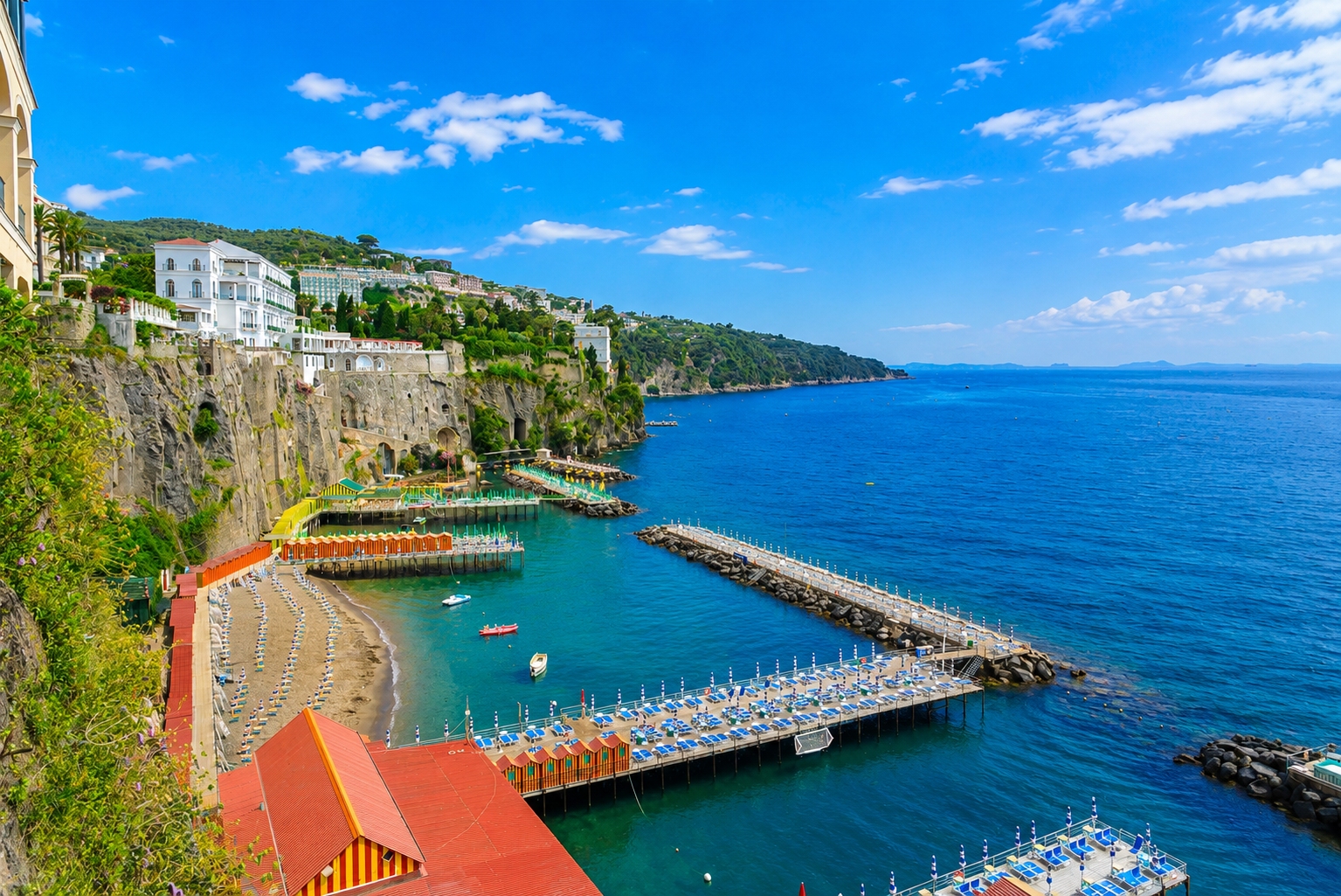 The iconic marina and coastal cliffs in Sorrento, Italy on the Amalfi Coast with hotels and restaurants perched on top.