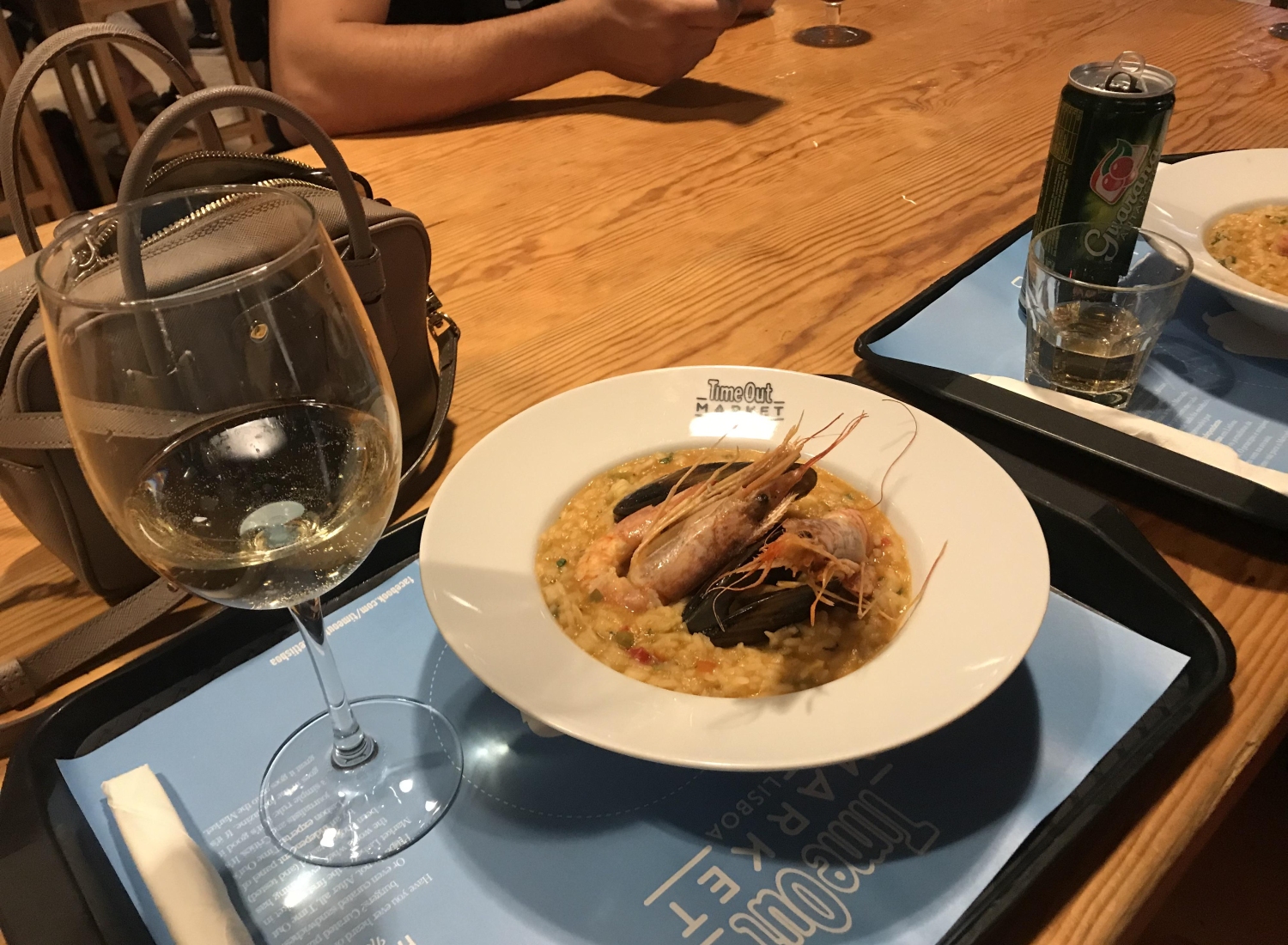 A meal at Time Out Market Lisboa in Lisbon, Portugal accompanied by a glass of white wine, which is often Vinho Verde in this region.