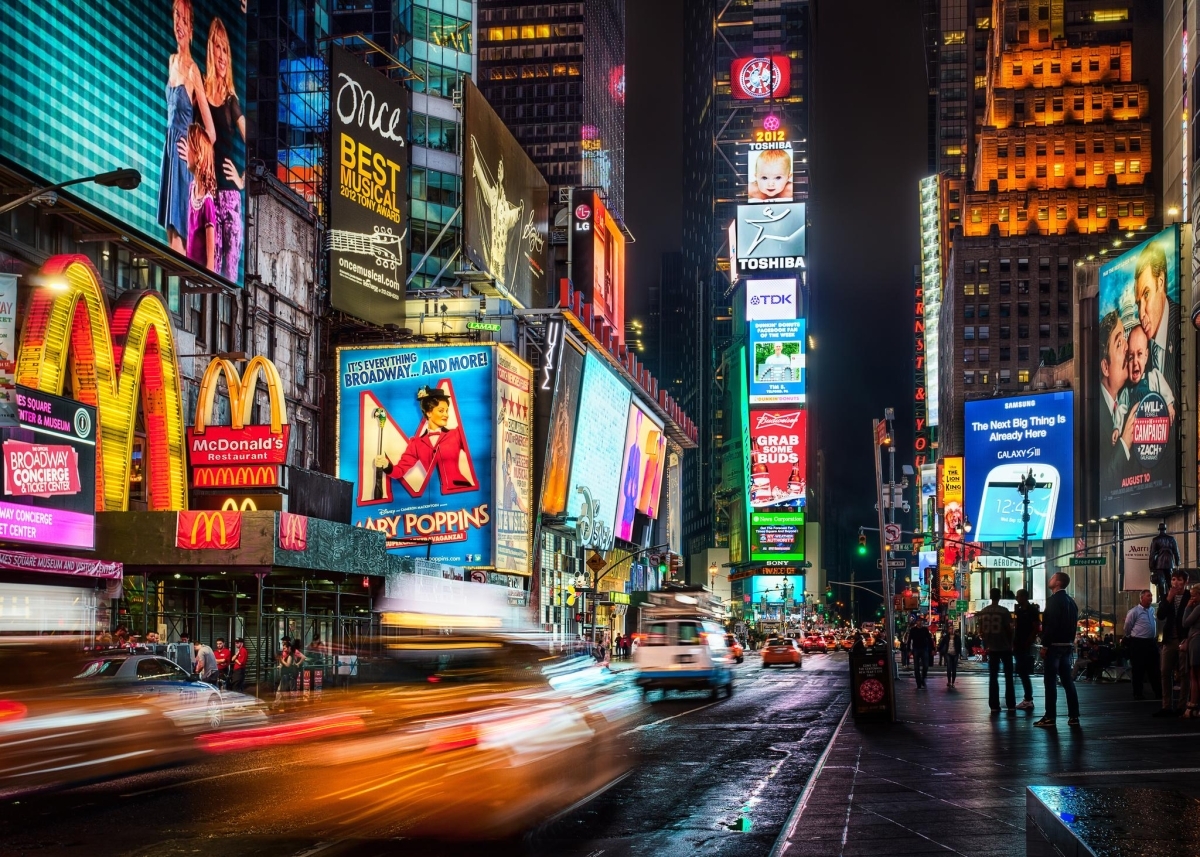 Times Square in New York City at night, showcasing illuminated billboards.